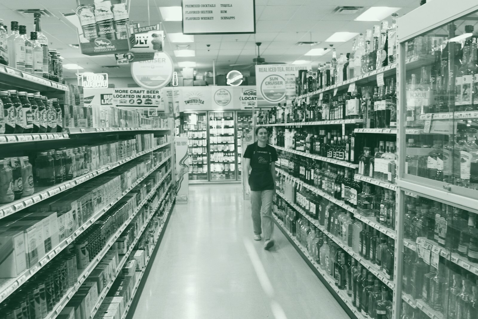 A person walks down a brightly lit grocery store aisle