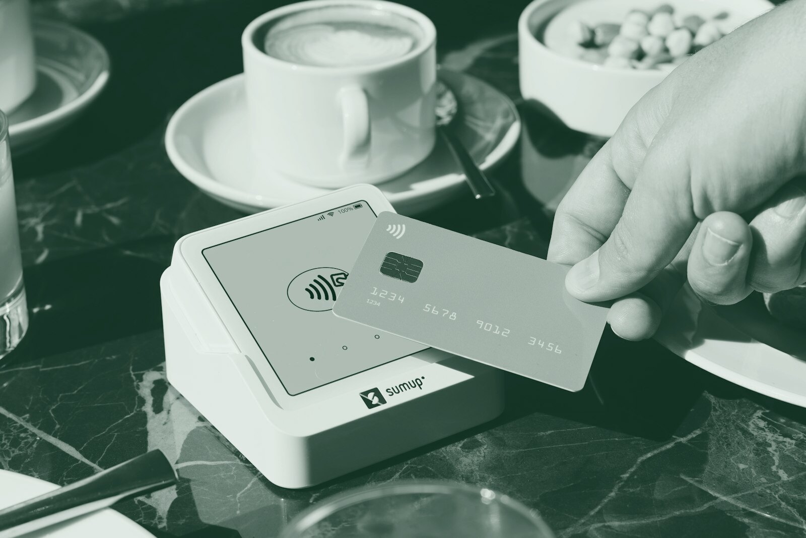 A person holding a credit card over a table