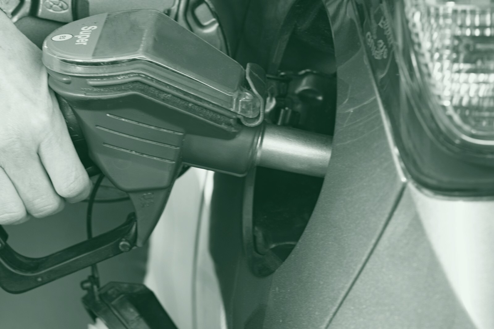 a person pumping gas into a car at a gas station