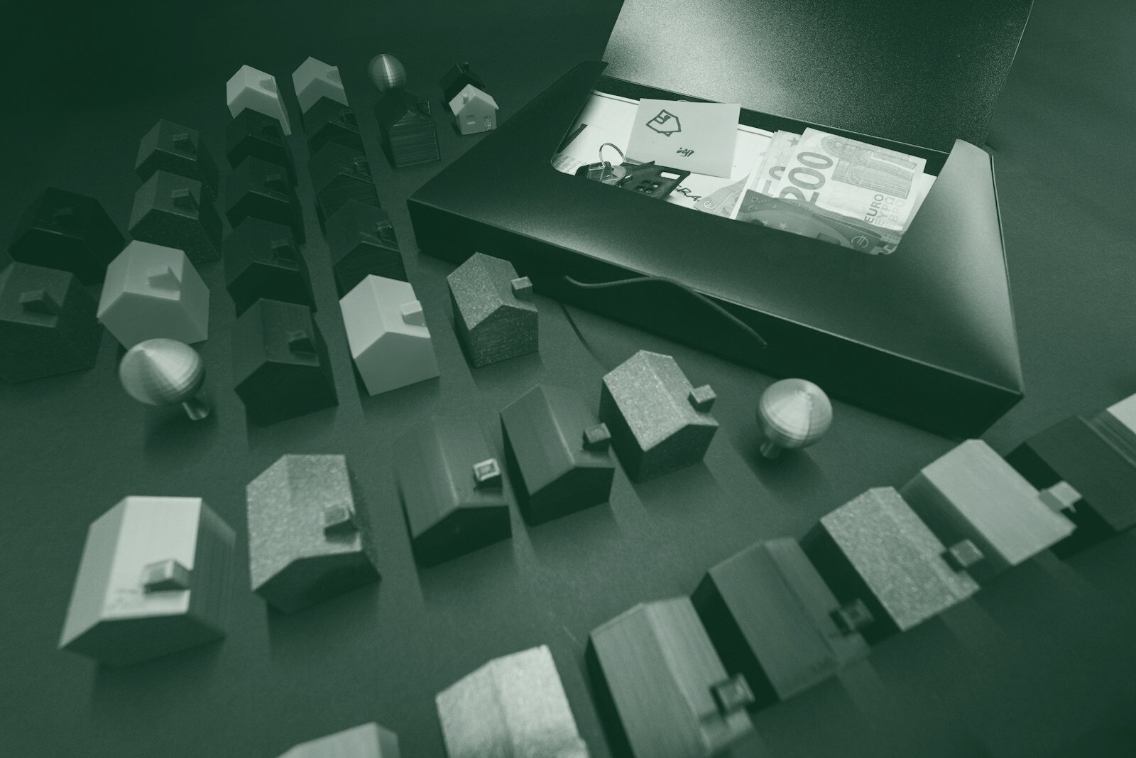 Miniature houses arranged with cash in an open box